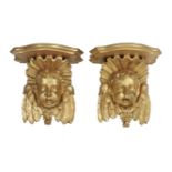 A pair of 18th century-style gilt wood wall brackets in the form of winged cherubs heads, each
