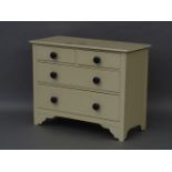 A small painted chest of two small and two large drawers, cream with blue knobs