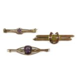 Two gold amethyst and split pearl bar brooches, marked 9ct, a 9ct gold pearl and paste horse shoe