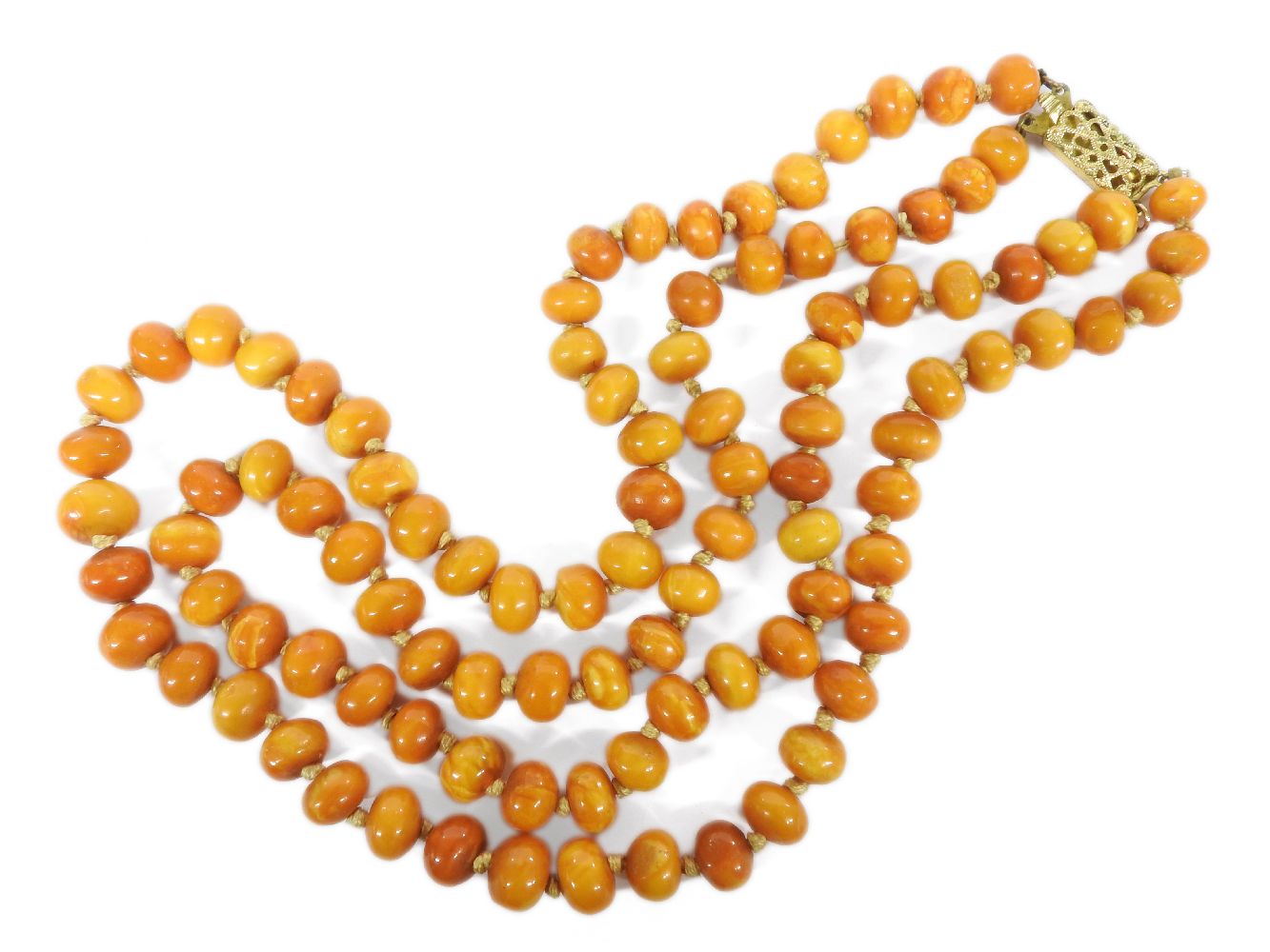 A two row graduated bouton shaped amber bead necklace, with gilt metal clasp, 60.46g