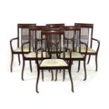 A set of six Edwardian mahogany dining chairs, with spindle turned backs and open arms, each bearing