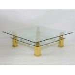 A modern square coffee table, the glass top on four gilt lion supports, lower glass shelf and