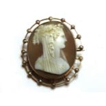 An Edwardian gold shell cameo brooch, of a young maiden, with garland to hair, the mount set with