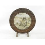 A French walnut table, the circular top mounted with a military scene depicting soldiers around a