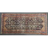 A hand knotted Persian rug, the navy fields with multi geometric decoration and triple border (