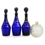 Three Bristol blue glass Hollands, brandy and rum decanters, 24.5cm high, a cut glass ball, 13cm