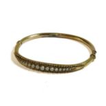 A Victorian gold hinge bangle, set with a graduated row of split pearls, 6.80g