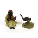 A cold painted duck, fixed on an onyx base, 6.5cm high and a painted metal figure of a nodding Arab