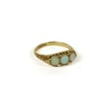 An Edwardian 18ct gold boat shaped three stone opal ring, with scroll shoulders, Birmingham, 1905