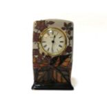 A modern Moorcroft clock, decorated with autumnal leaves and berries, approximately 16cm tall