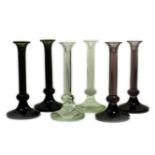 Three pairs of decorative glass candlesticks, in amethyst, emerald and clear, 45cm high