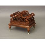 A Victorian walnut three division Canterbury, with fret cut decoration over a base drawer and turned