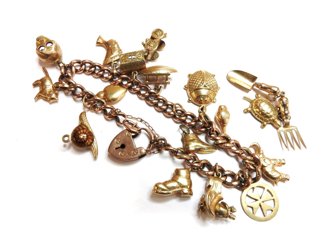 A gold hollow curb link charm bracelet, with twelve assorted gold charms, to include a 9ct gold