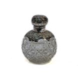 An Edwardian silver mounted perfume bottle, the globular cut glass body with foliate decoration,