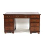 A reproduction mahogany twin pedestal desk, with red leather lined top above and arrangement of nine