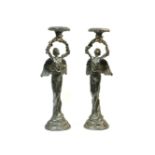 A pair of cast iron candlesticks, in the form of angels with their arms held aloft