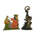Two cast iron and painted door porters, one in the form of Jesus at the well, the other a putti, the
