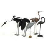 A collection of four patinated wrought iron garden sculptures, in the form of herons
