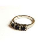 An 18ct white gold three stone sapphire and diamond half hoop ring, 3.87g