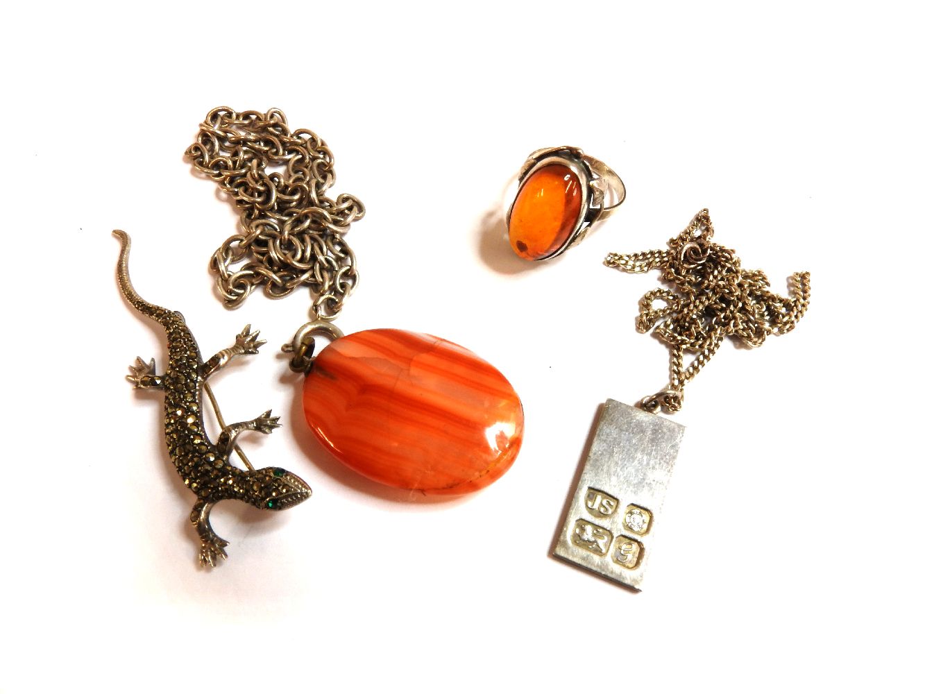 A silver amber cabochon ring, a silver ingot pendent by Jack Spencer, 1981, on chain, a banded agate