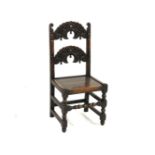 An oak side chair, 17th century style, solid seat and carved bar back