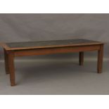 An oak library table, with a green leather top, central with a copper plaque inscribed 'This table