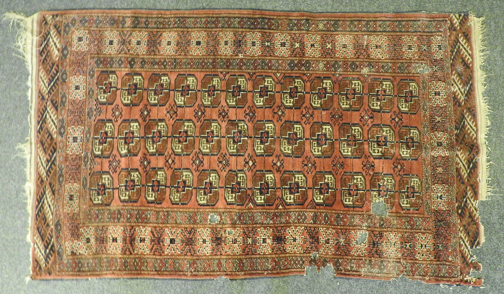 A Bokhara rug, the red fields with repeated geometric decoration and one other similar (both AF)