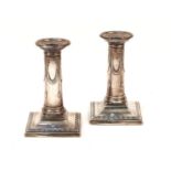 A pair of silver candlesticks, with ribbon swag, removable drip pans, weighted, 13cm high