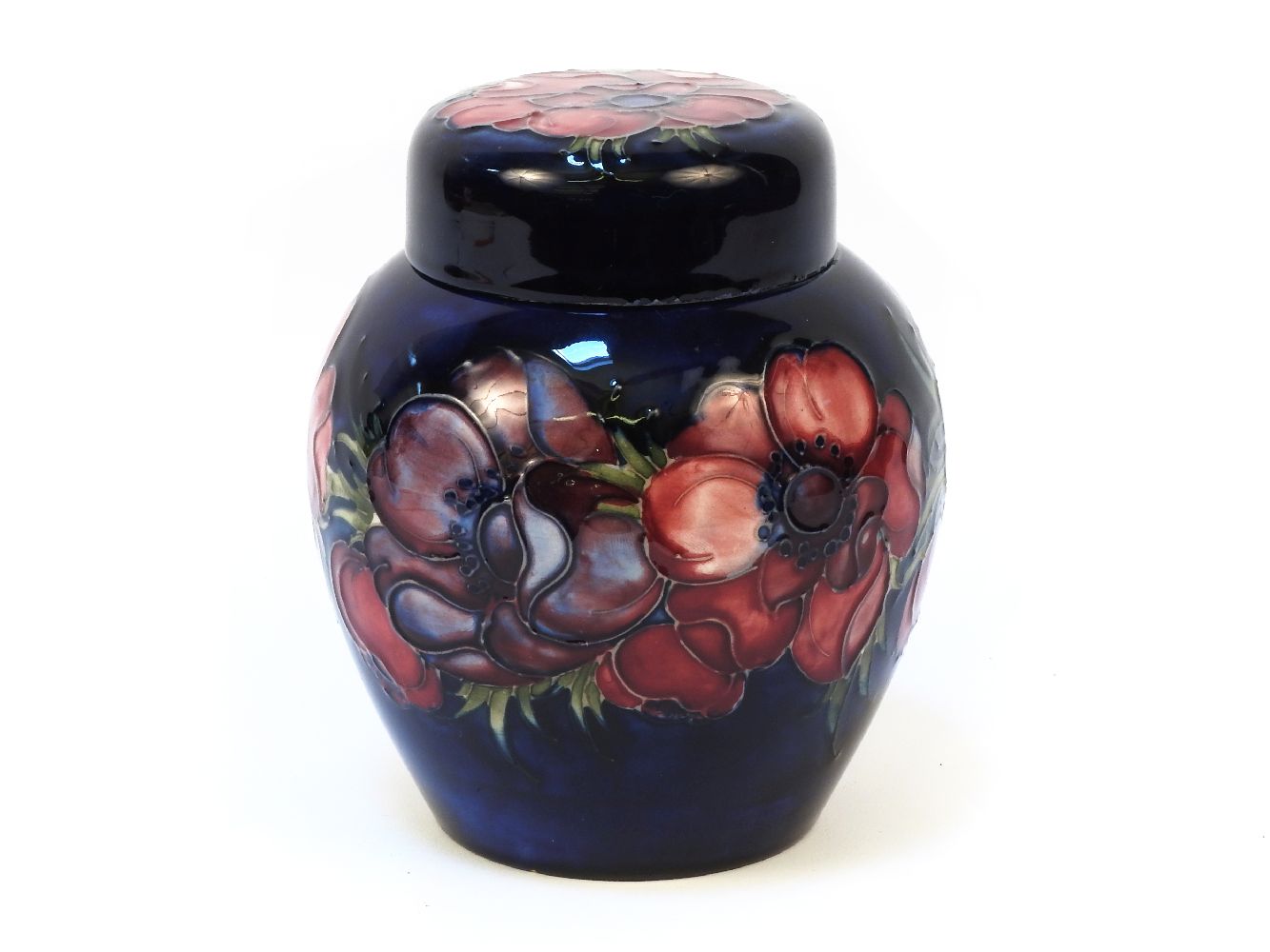 A Walter Moorcroft Clematis pattern ginger jar and cover, the blue glazed body with tube line