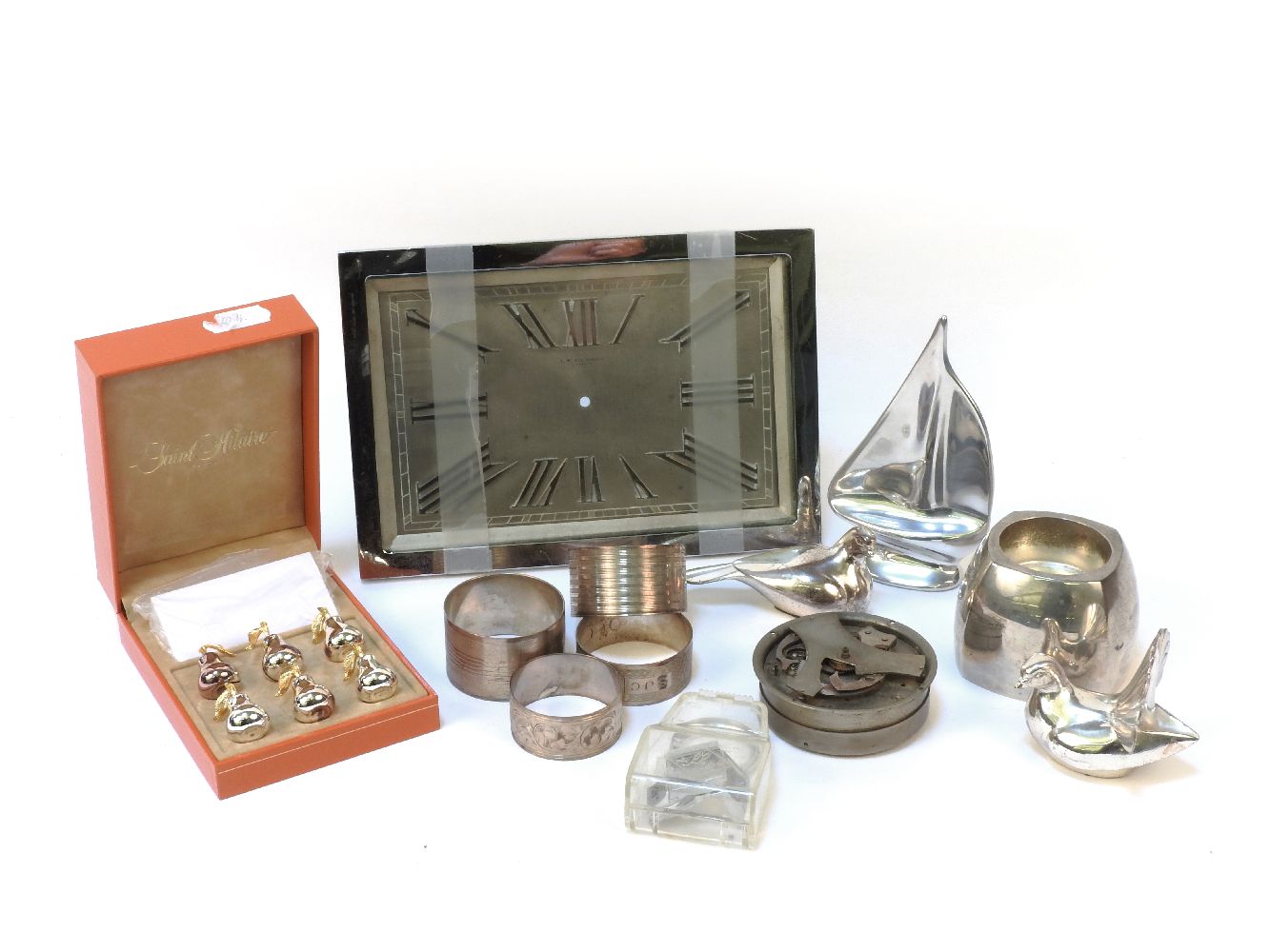 A chrome framed Benson mantel clock, four silver napkin rings, two silver doves and similar