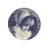 A Victorian charger painted with a portrait of a lady in a bonnet, singed in blue, 36cm diameter