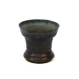 A small bronze mortar, inscribed, 'AERMAR VINCIT OMIA Ao 1664' with bands of stylised foliate