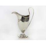 A George III silver helmet shaped cream jug, maker's mark for Nathanial Smith & Co., Sheffield,
