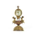 A French gilt metal and porcelain cherub mantel clock. 28cm high