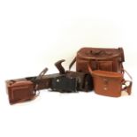 A collection of black planes, binoculars, Zeiss Ikon camera, and other accessories