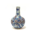 A late 19th century porcelain bottle vase, decorated in under glaze blue and pink, with a peach