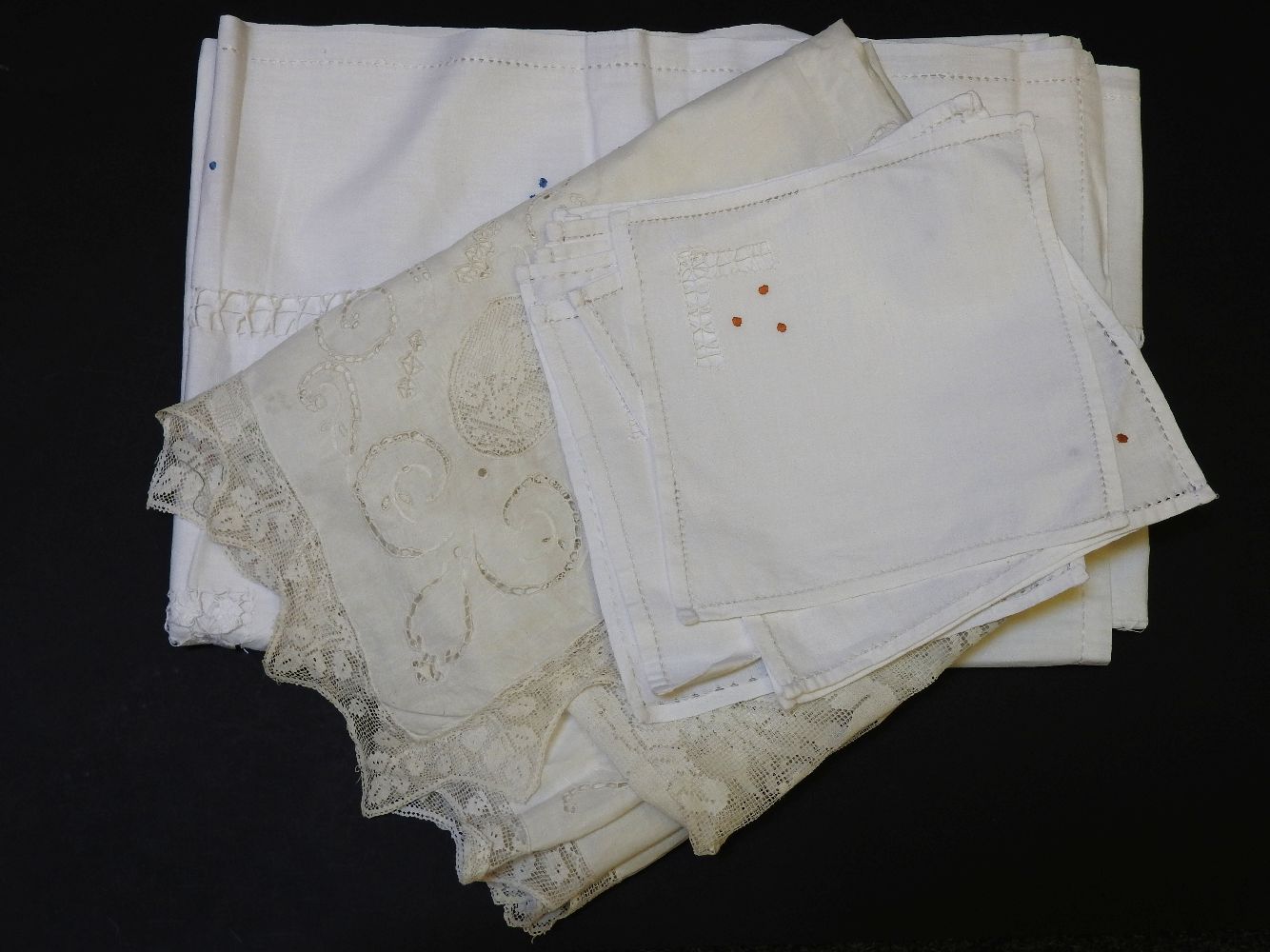 Two embroidered linen tablecloths, and ten napkins, the largest 166cm x 244cm