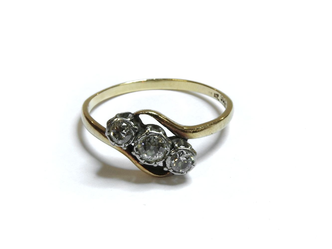 A gold three stone diamond crossover ring, marked 9ct and plat