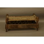 A North African carved wood and woven skin bench, 110cm wide, 60cm deep, 50cm high