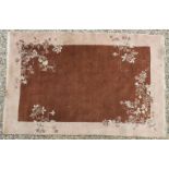 An Oriental woollen rug, the brown fields with flower head design, 260cm x 183cm