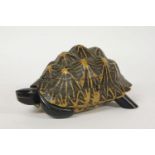 A Tortoise jewellery box, c.1930, with fitted marquetry interior and ebonised head and legs29cm