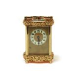 A French brass carriage clockwith fretted brass decoration16.5cm high to top of handle