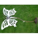 A steel garden sculpture in the form of a butterfly, with pierced wings, and on scrolling stand,