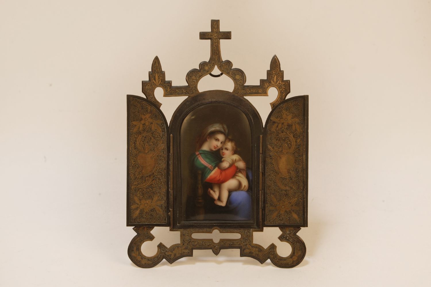 A porcelain icon possibly KPM depicting a panel of The Madonna and child in a gilt/plated stand,
