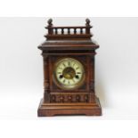 An early 20th century German walnut cased mantel clock, with gong strike movement and enamel chapter