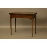 An Edwardian inlaid mahogany fold over card table, on slender square tapering supports, 83cm wide,