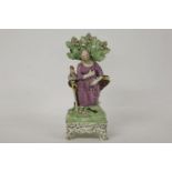 A Staffordshire table base pearlware figure of St Peter, holding keys, flanked by a hen and a bible,