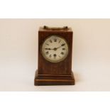 A late Victorian inlaid rosewood mantel clock, the white enamel dial with Roman numerals, fitted