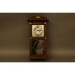 An early 20th century oak cased wall clock