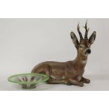 A terracotta reclining figure of a deer, together with a green art glass bowl